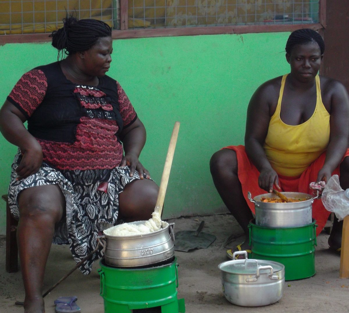 African ladies cooking rice with CFN briquettes